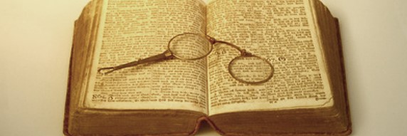 Aufgelschlagenes altes Buch mit Brille - Archiv kaminholz-wissen