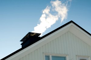 Rauchender Schornstein auf dem Dach eines Hauses